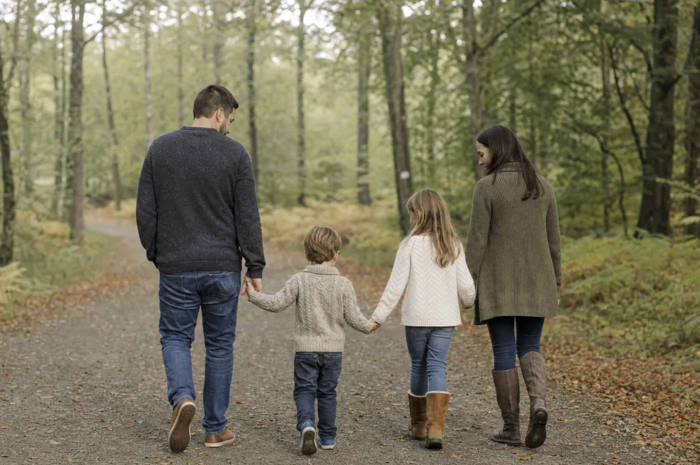 Family walking together outdoors, shot candidly from behind in natural light