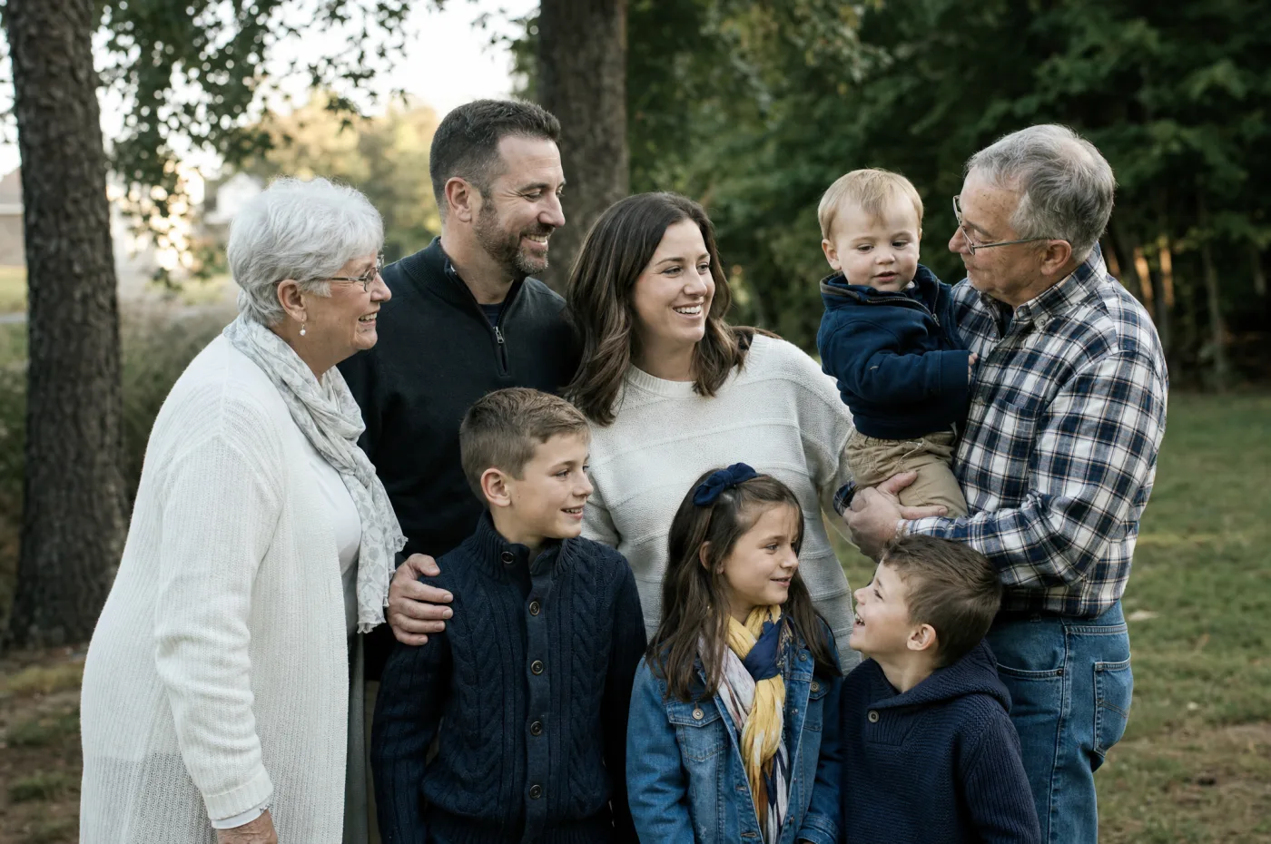 Multi-generation family group candidly gathered outdoors in natural light